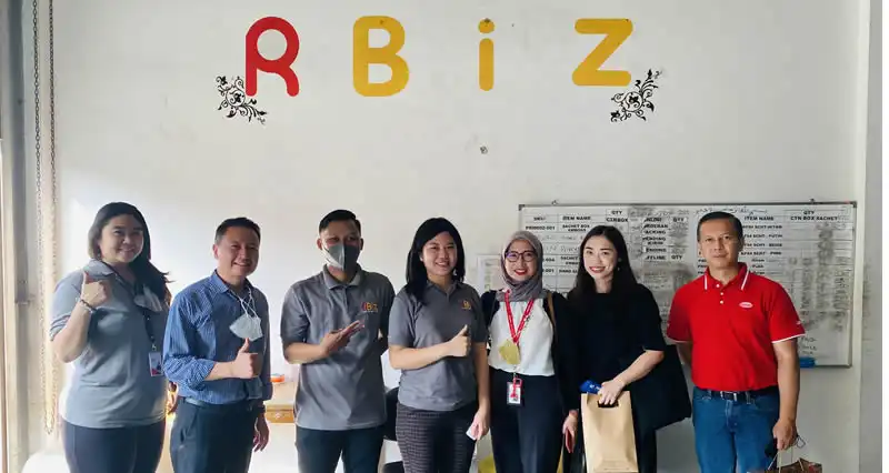 RBiz team gathered in front of the RBiz wall